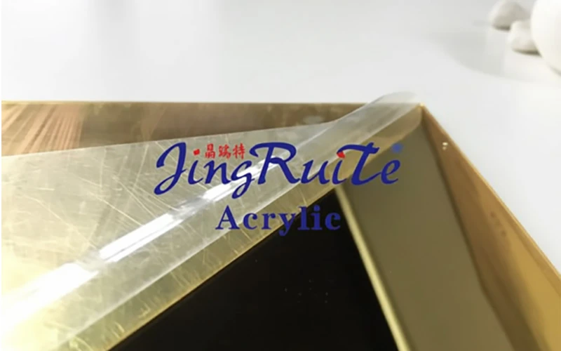 Gold mirror acrylic sheet with protective film peeled back for custom processing and fabrication