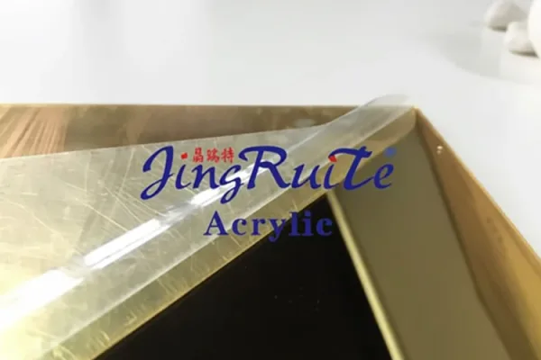 Gold mirror acrylic sheet with protective film peeled back for custom processing and fabrication